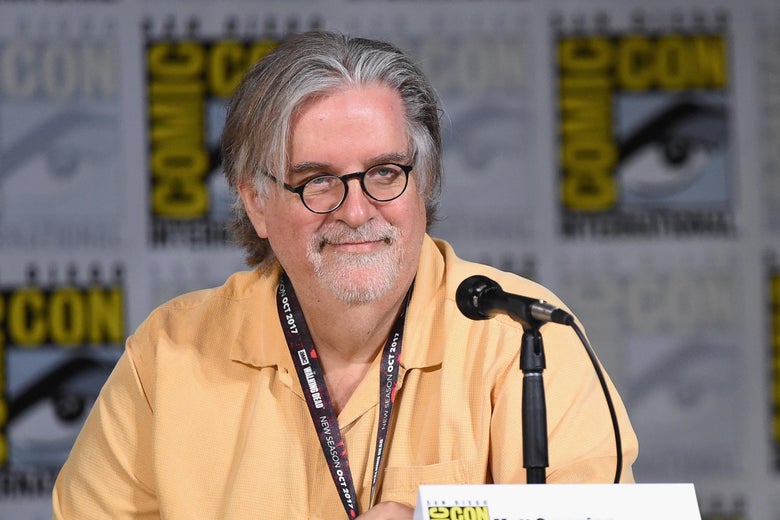 Matt Groening sitting at a Comic-Con panel table.